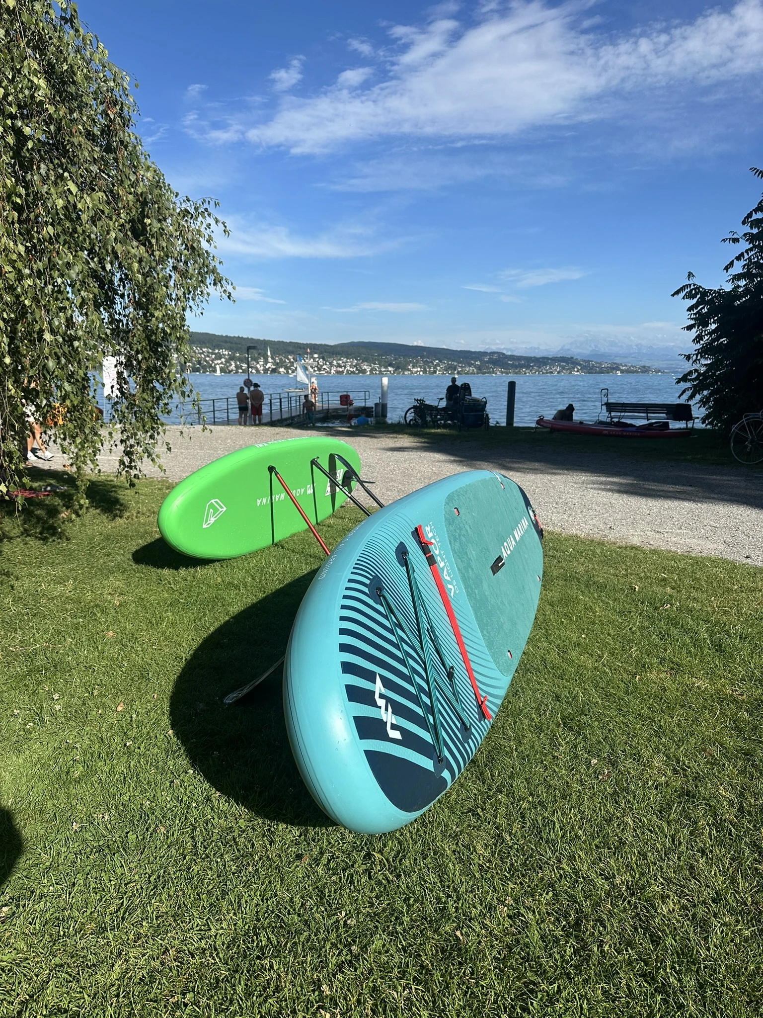 Person sitting on green inflatable SUP board on Lake Zurich